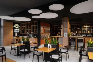 a restaurant with tables and chairs and lights on the ceiling at Park Inn by Radisson Vilnius Airport Hotel & Conference Centre in Vilnius