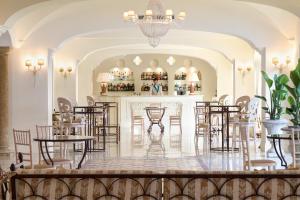 una habitación con mesas y sillas y un bar en Almar Giardino di Costanza Resort & Spa, en Mazara del Vallo