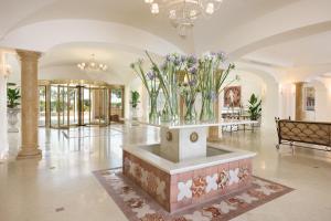 マツァーラ・デル・ヴァッロにあるAlmar Giardino di Costanza Resort & Spaの花瓶をテーブルに置いたロビー