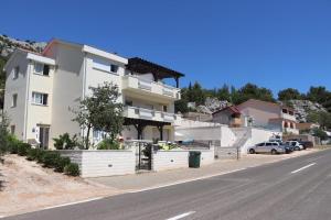 biały budynek po stronie ulicy w obiekcie Apartment Petra w mieście Starigrad-Paklenica