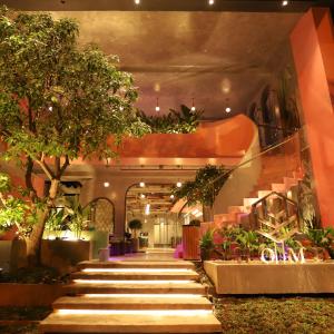 a lobby with stairs with trees and plants at HOME Hotel in Ho Chi Minh City