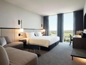 a hotel room with a bed and a couch at Hyatt Place Melbourne Caribbean Park in Scoresby