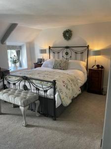 een slaapkamer met een groot bed met een metalen frame bij Beautiful 1 bed thatched cottage in Dolton