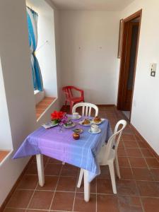 a table with a blue table cloth and red chairs at Hotel Residence Il Mulino in Alicudi