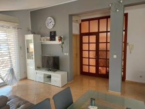 a living room with a couch and a tv at Apartments Prgin in Primošten