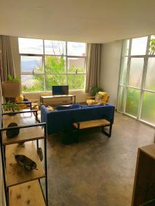 a living room with a blue couch and windows at Eagle View Lodge - Kigali in Kigali