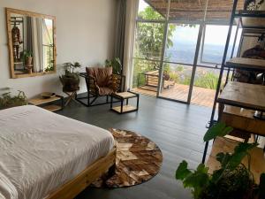 Schlafzimmer mit einem Bett und Blick auf einen Balkon in der Unterkunft Eagle View Lodge - Kigali in Kigali