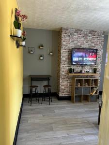 a living room with a tv and a brick wall at Nuns Moor fully equipped kitchen free parking Netflix in Newcastle upon Tyne