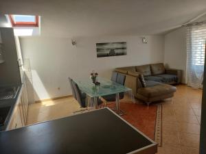 a living room with a table and a couch at Apartments Prgin in Primošten