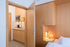 a bedroom with a bed and a small kitchen at Draxl-Hof Ferienwohnungen in Weissensee