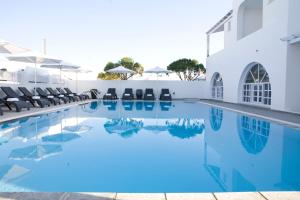 a swimming pool with blue water in a hotel at Philippion Boutique Hotel in Fira