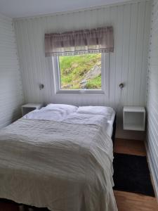 sypialnia z łóżkiem i oknem w obiekcie Aktiv ferie i Vesterålen, Hovden 8475 Straumsjøen w mieście Hovden