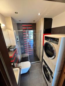 uma pequena casa de banho com uma máquina de lavar roupa e uma máquina de lavar roupa em APARTAMENT LOFT z ANTRESOLĄ w GDAŃSKU em Gdansk