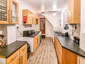 a kitchen with wooden cabinets and black counter tops at * Ipswich Suffolk Contractor Holiday Short Stay * in Whitton