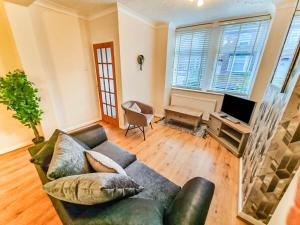 a living room with a couch and a television at * Ipswich Suffolk Contractor Holiday Short Stay * in Whitton