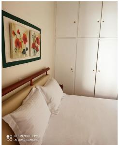 sypialnia z łóżkiem i obrazem na ścianie w obiekcie Ομορφο διαμέρισμα κοντά στο σταθμό Δουκίσσης Πλακεντίας w Atenach
