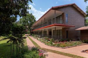 a building with a balcony and flowers in front of it at Oleander Farms, Karjat in Karjat