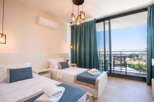a bedroom with two beds and a large window at VILLA ALKIM in Kaş +49 photos
