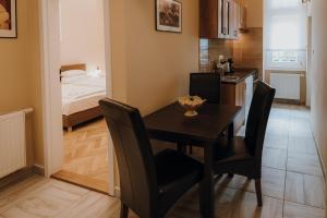 a kitchen and dining room with a table and chairs at Dózsa Apartman Szeged in Szeged