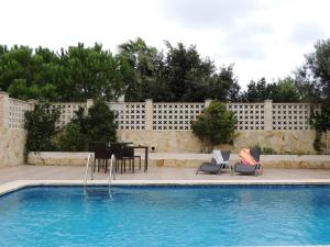 a pool with chairs and a table next to a fence at Villa Ca Na Llum in Trebeluger