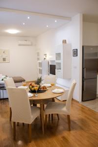 a kitchen and dining room with a wooden table and chairs at Apartman Maša in Šibenik