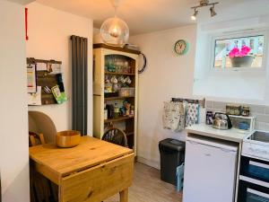 a kitchen with a wooden table and a counter top at Campion Cottage in Brixham