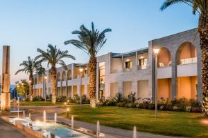 a building with palm trees in front of it at Magdala Hotel in Migdal