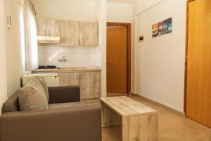 uma sala de estar com um sofá e uma mesa de madeira em Vicky em Hanioti