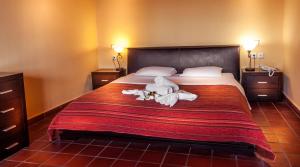 a bedroom with a bed with two stuffed animals on it at Kallisti Hotel in Potos