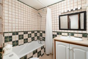 a bathroom with a tub and a sink and a mirror at Praia de Alvor in Alvor +21 photos