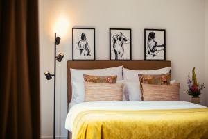 ein Schlafzimmer mit einem Bett mit vier Bildern an der Wand in der Unterkunft The Weinmeister Berlin-Mitte - Adults Only in Berlin