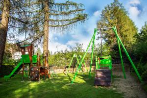 einen Spielplatz mit einer grünen Schaukel im Hof in der Unterkunft DW Halicz in Solina