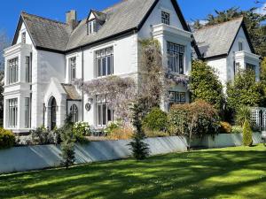 una gran casa blanca con un gran patio en Penarwyn House, en Par