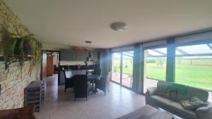 ein Wohnzimmer mit einem Sofa und eine Küche mit einem Tisch in der Unterkunft Gîte La Besse, Claudon in Claudon
