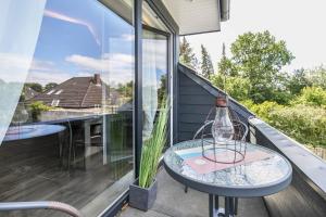 a glass bottle on a table on a balcony at Uhse Wohlfühloase in Heide