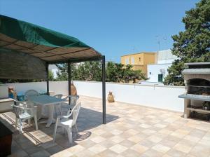 eine Terrasse mit einem Tisch, Stühlen und einem Kamin in der Unterkunft Villa nel Salento - Casa Maria e Casa Glory in Porto Cesareo