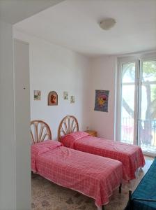 two beds in a room with red sheets at Villa nel Salento - Casa Maria e Casa Glory in Porto Cesareo