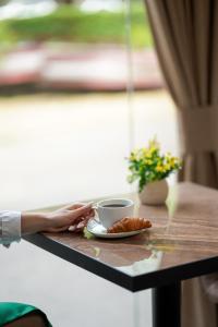 a table with a cup of coffee and a plate of food at Good Hotel Yerevan in Yerevan