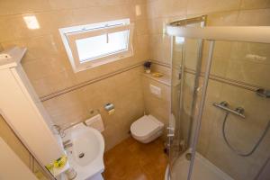 a small bathroom with a toilet and a shower at Beach House Splitska in Splitska +19 photos