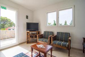 a living room with two chairs and a tv at Beach House Splitska in Splitska
