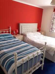 a bedroom with a bed and a red wall at 94 Main Street - Pembroke Holiday Home in Pembroke