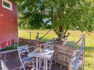 a table and chairs and some kangaroos behind a fence at Tiny House auf der Alpaka Farm in Rubkow