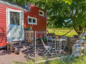 Rubkow的住宿－Tiny House auf der Alpaka Farm，红色的房子,外面配有桌椅