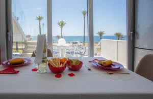 una mesa con comida y vistas al océano en Apartamentos Buendía en El Puerto de Mazarrón