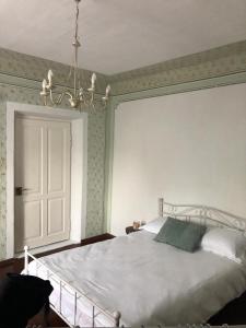 1 dormitorio con 1 cama blanca grande con lámpara de araña en Texas House, en Novaci-Străini