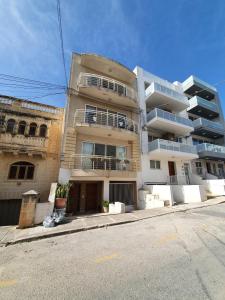 un edificio de apartamentos al lado de una calle en Modern Apartment in Swieqi Malta, en San Julián