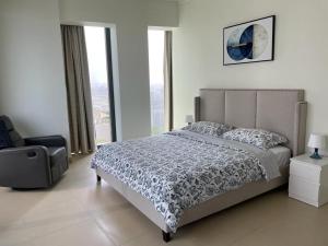 Schlafzimmer mit einem Bett, einem Stuhl und Fenstern in der Unterkunft Burj Khalifa view-Access to Dubai mall-Downtown in Dubai