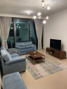 ein Wohnzimmer mit 2 Sofas und einem TV in der Unterkunft Burj Khalifa view-Access to Dubai mall-Downtown in Dubai