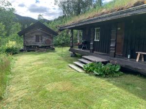 a log cabin with a grass roof and some plants at Kultan in Åmotsdal