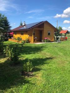 une petite maison jaune avec une cour devant elle dans l'établissement Domek na wyłączność z dużym ogrodem, à Jabłonka